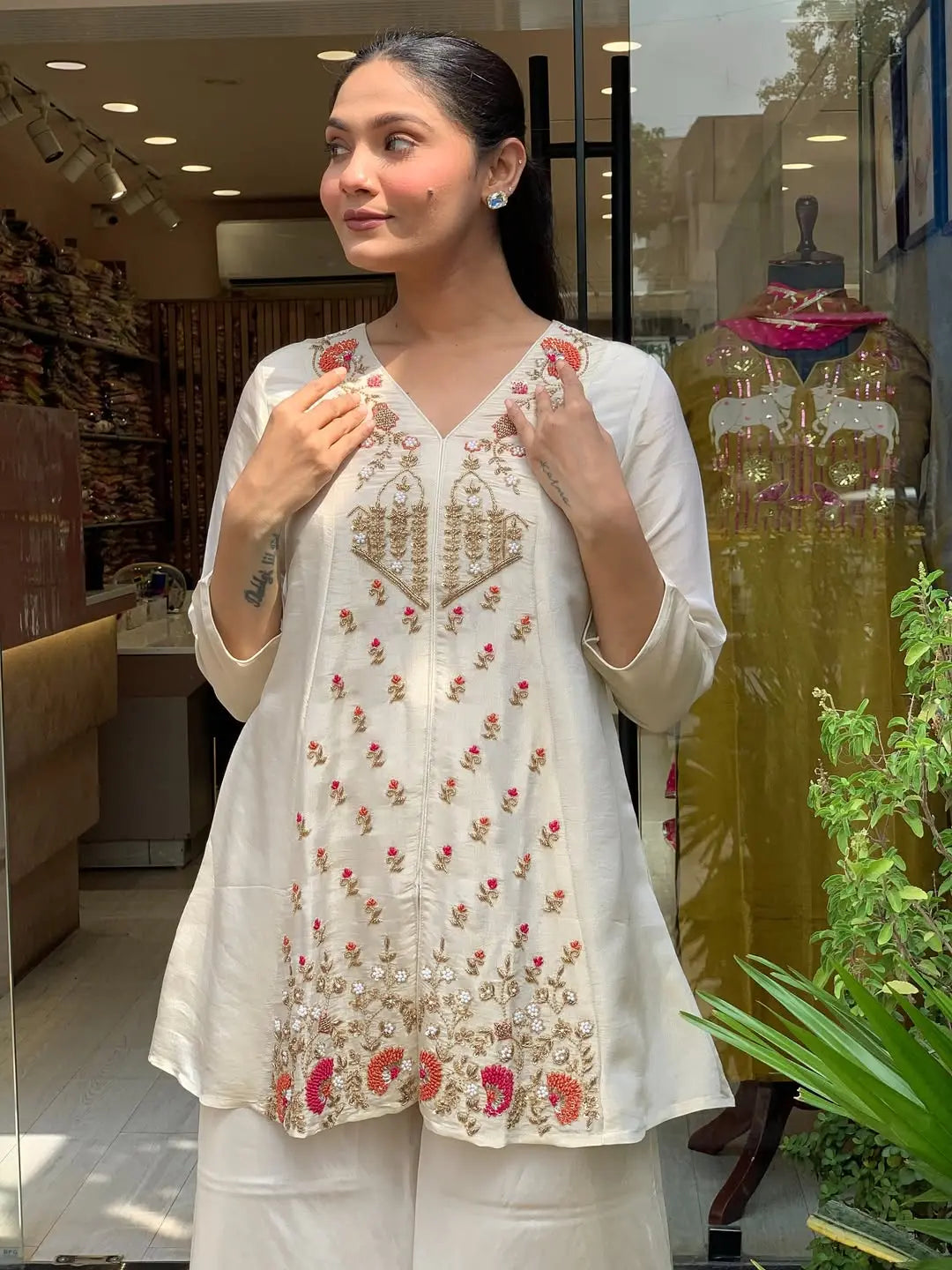 Woman wearing a white embroidered kurta in a store setting